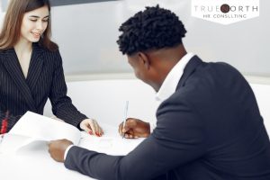 Business man and woman signing papers.