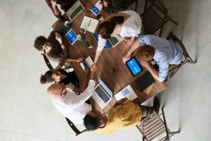 Business professionals working on laptops at a table from a bird's eye view.