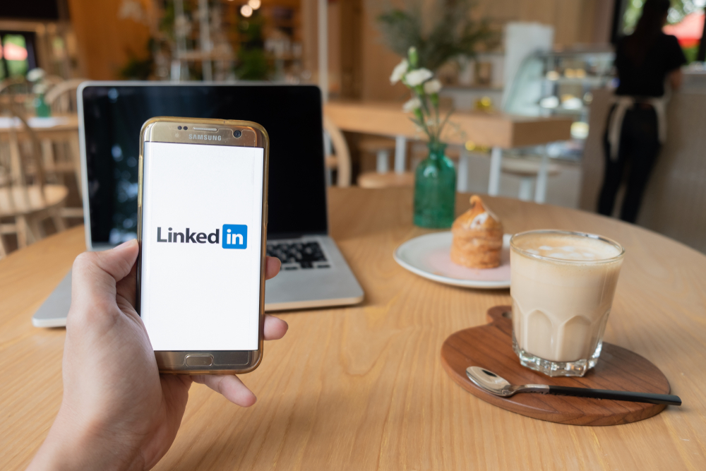 Person holding phone with LinkedIn app open.