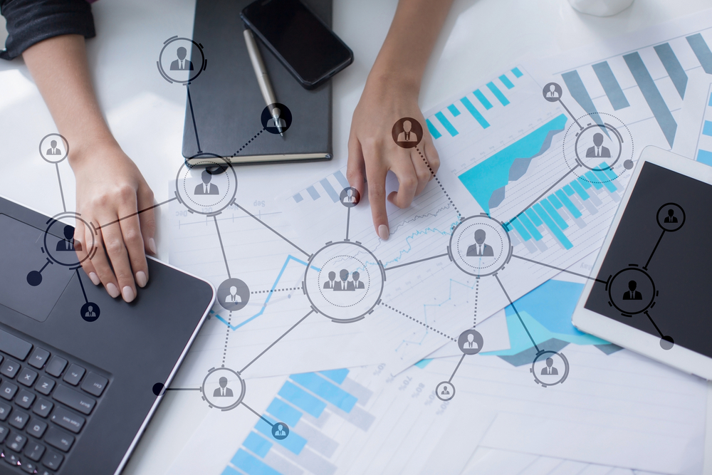 Business person working on laptop, surrounded by social network icons.