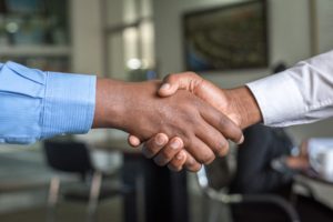 Two individuals shaking hands in a professional setting.