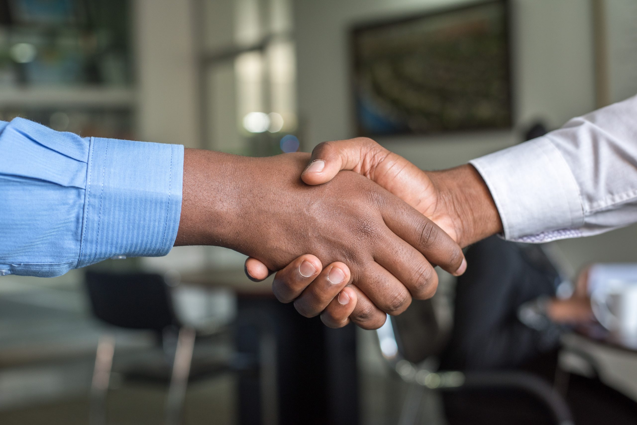 Two individuals shaking hands in a professional setting.