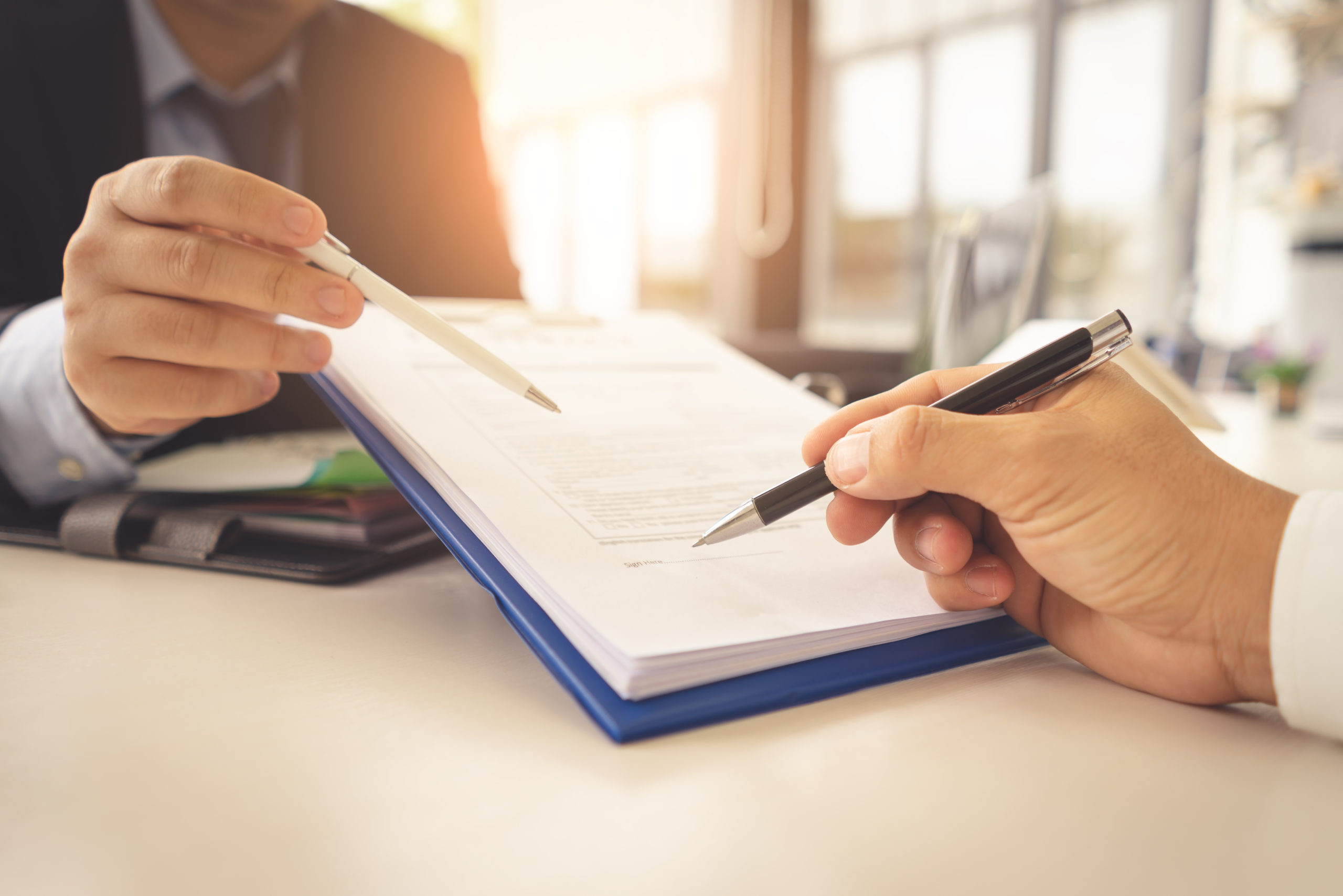 Two people reviewing a policy checklist for employers.