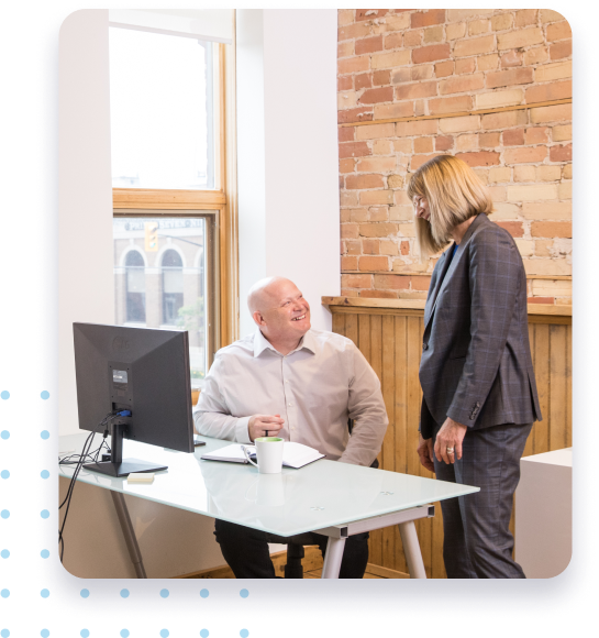 Man and woman talking at computer desk