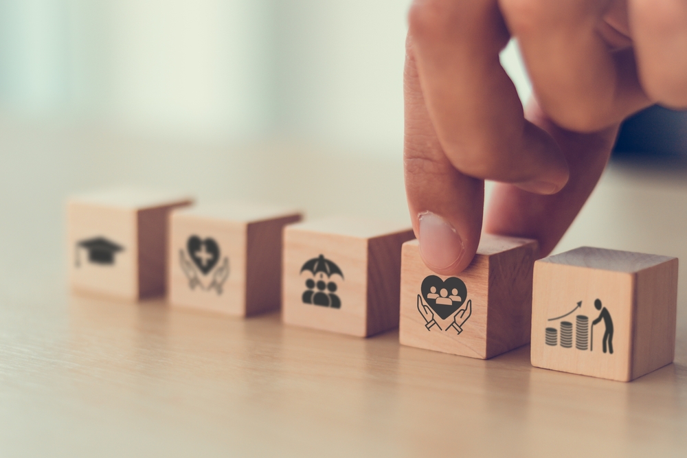 A person arranging wooden blocks with icons on them.