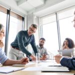 People around a table in a workplace discussing pay transparency
